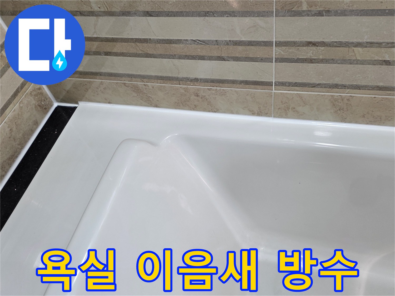 이 이미지는 욕실의 타일 벽면과-욕조가 만나는 접합부에-새롭게 적용된-고품질 방수 마감재를 보여주며-이는 물의 침투를 효과적으로 막아-누수를 예방합니다.