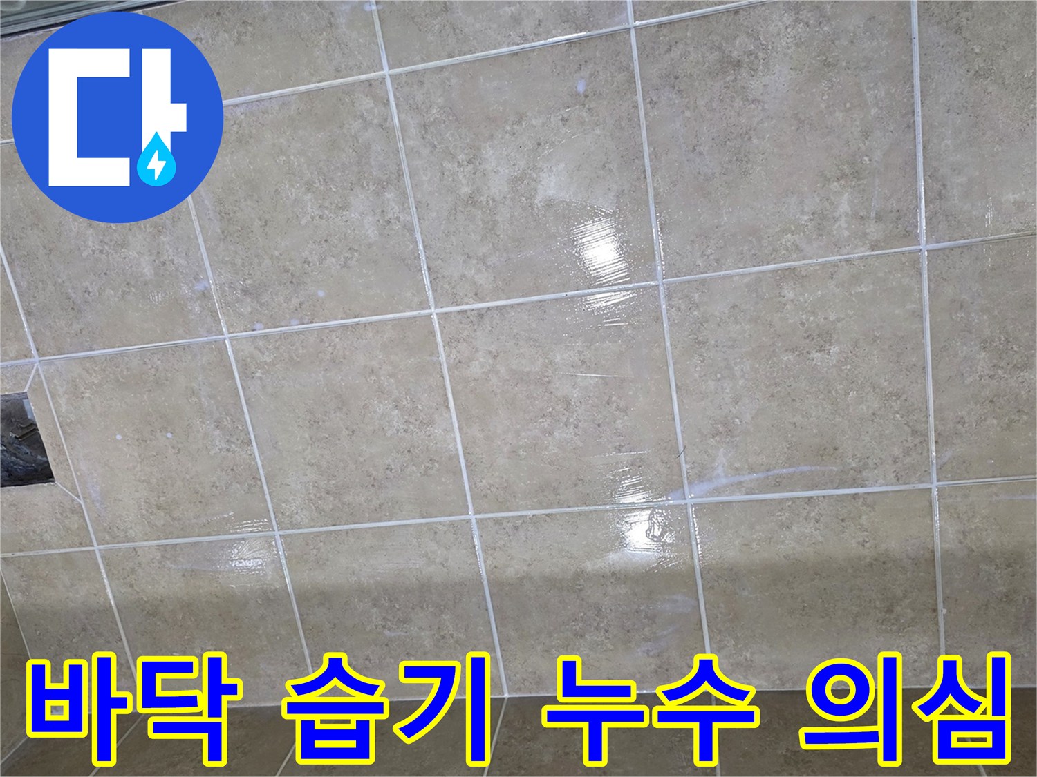타일 바닥에 넓게 퍼진 습기는 누수가 진행되고 있음을 시사하며-전문적인 탐지가 필요한 상황입니다