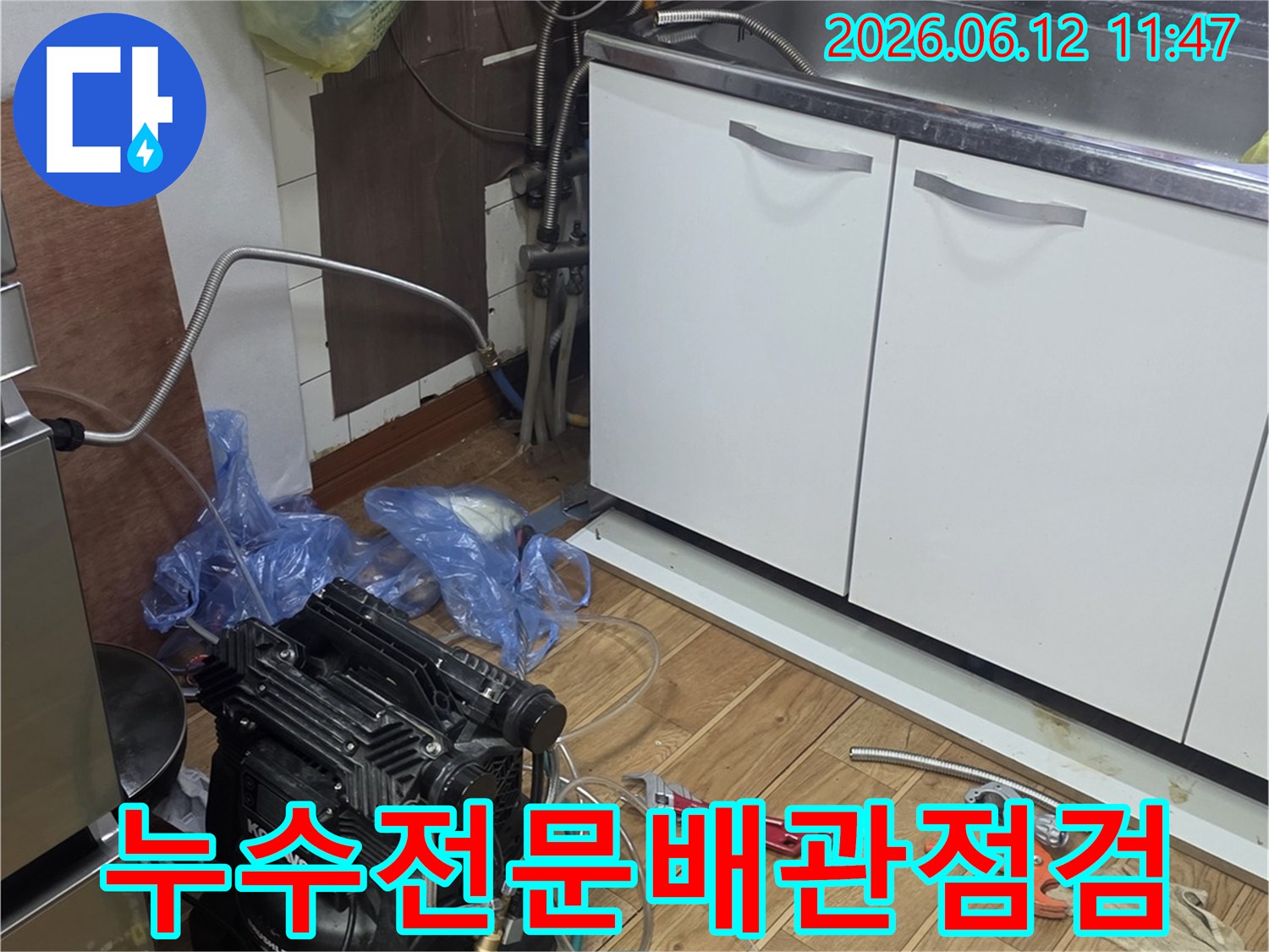 주방 싱크대 하부에서-누수 전문가가-배관 점검 작업을 진행하며-정밀하게 탐지하는 모습