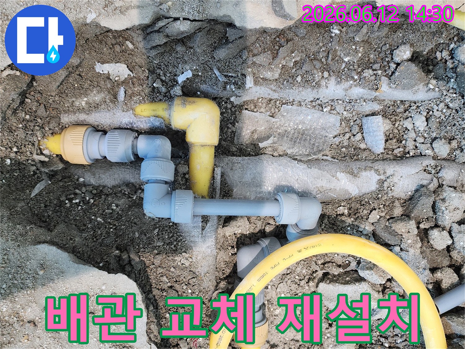 땅속에 매설된 노란색 가스-배관과 회색 수도-배관이 드러난 모습으로-누수 해결을 위한 배관-교체 및 재설치 현장입니다