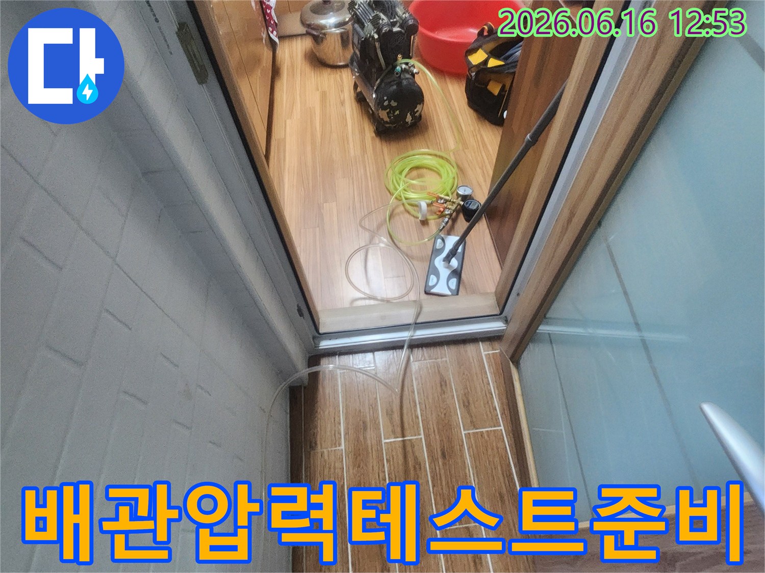 아파트 내부에서 누수 엔지니어가 배관 압력-테스트를 위한 장비 연결을 진행하고 있습니다.