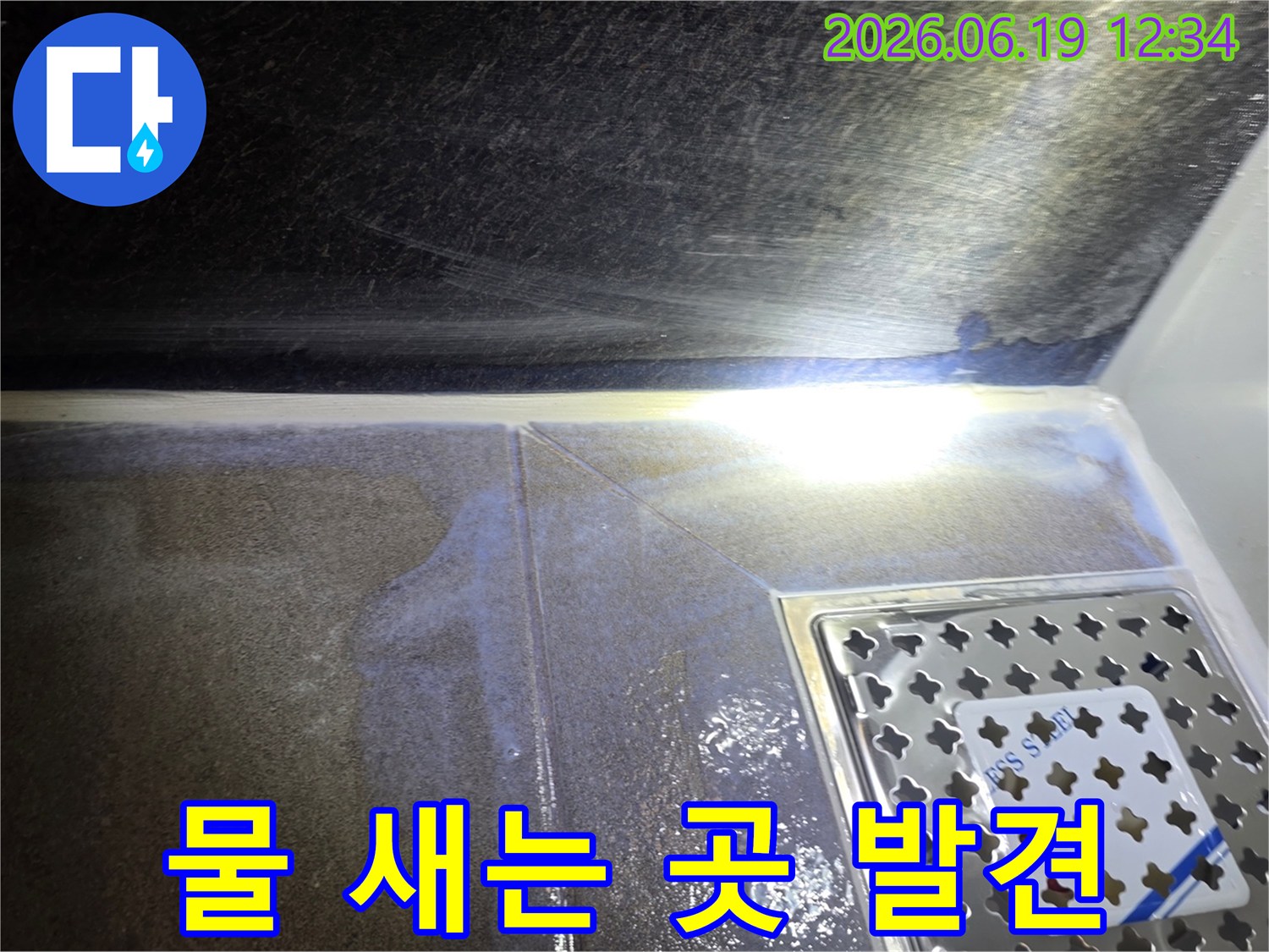 욕실-바닥-타일-사이와-배수구-주변에서-물이-새어-나와-고여있는-현장을-촬영한-사진입니다