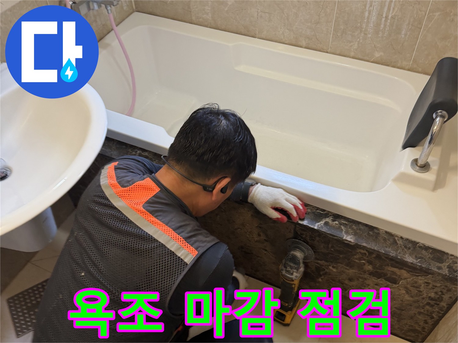 작업자가 욕조와 타일 사이의 틈새를 면밀히 조사하고 있습니다.