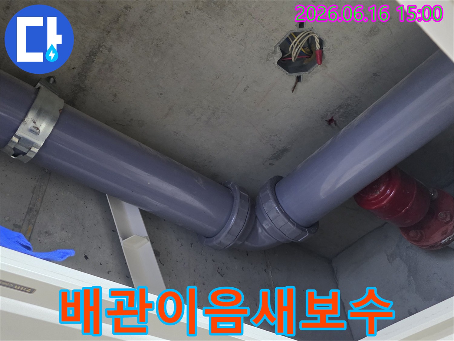 콘크리트-천장 아래-새로운-회색 배관의-엘보 연결 부위가-견고하게-설치된-모습을-보여주는-사진