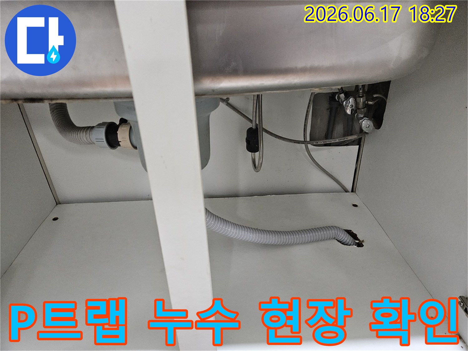 싱크대 P트랩과 배수 호스 연결 부위에서-누수 여부를 확인하고 있는 전문가의 시선입니다