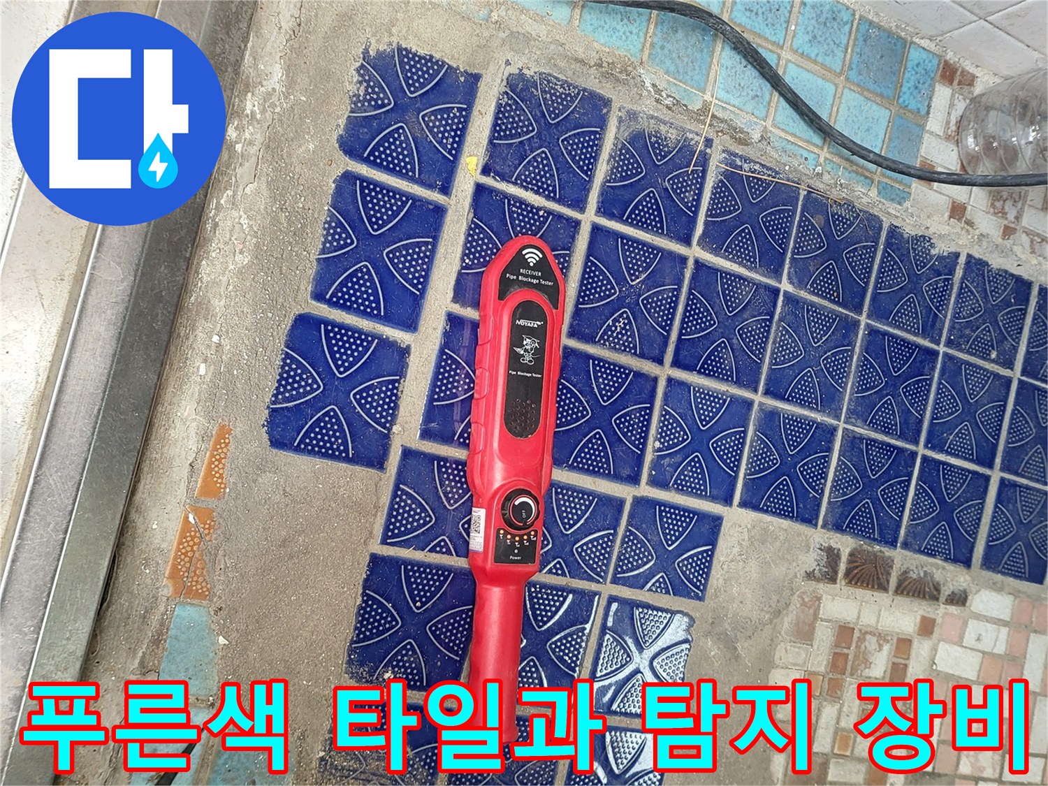 푸른색 패턴 타일 위에 놓인 빨간색 가스 탐지기