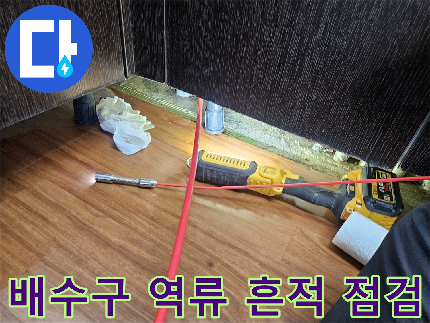 싱크대 아래쪽 배관 주변의 물샘 흔적과 점검 장비