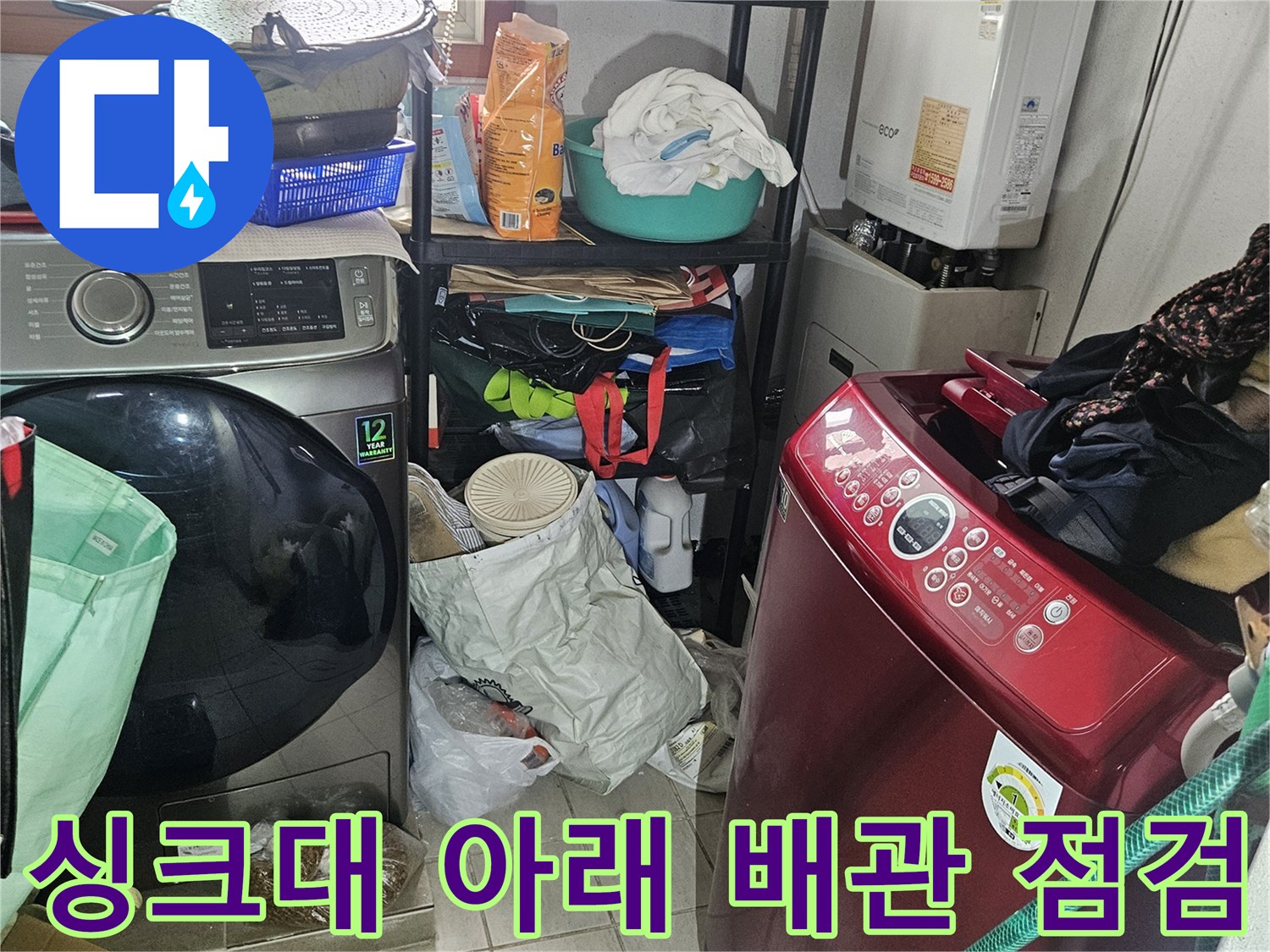 싱크대 하부장 내부의 복잡한 배관과 세탁기 주변 환경입니다.