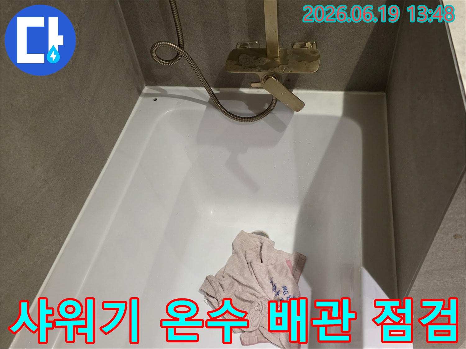 욕실 샤워기 온수 배관의-연결 부위와-주변 상태를 면밀히 점검하는 모습
