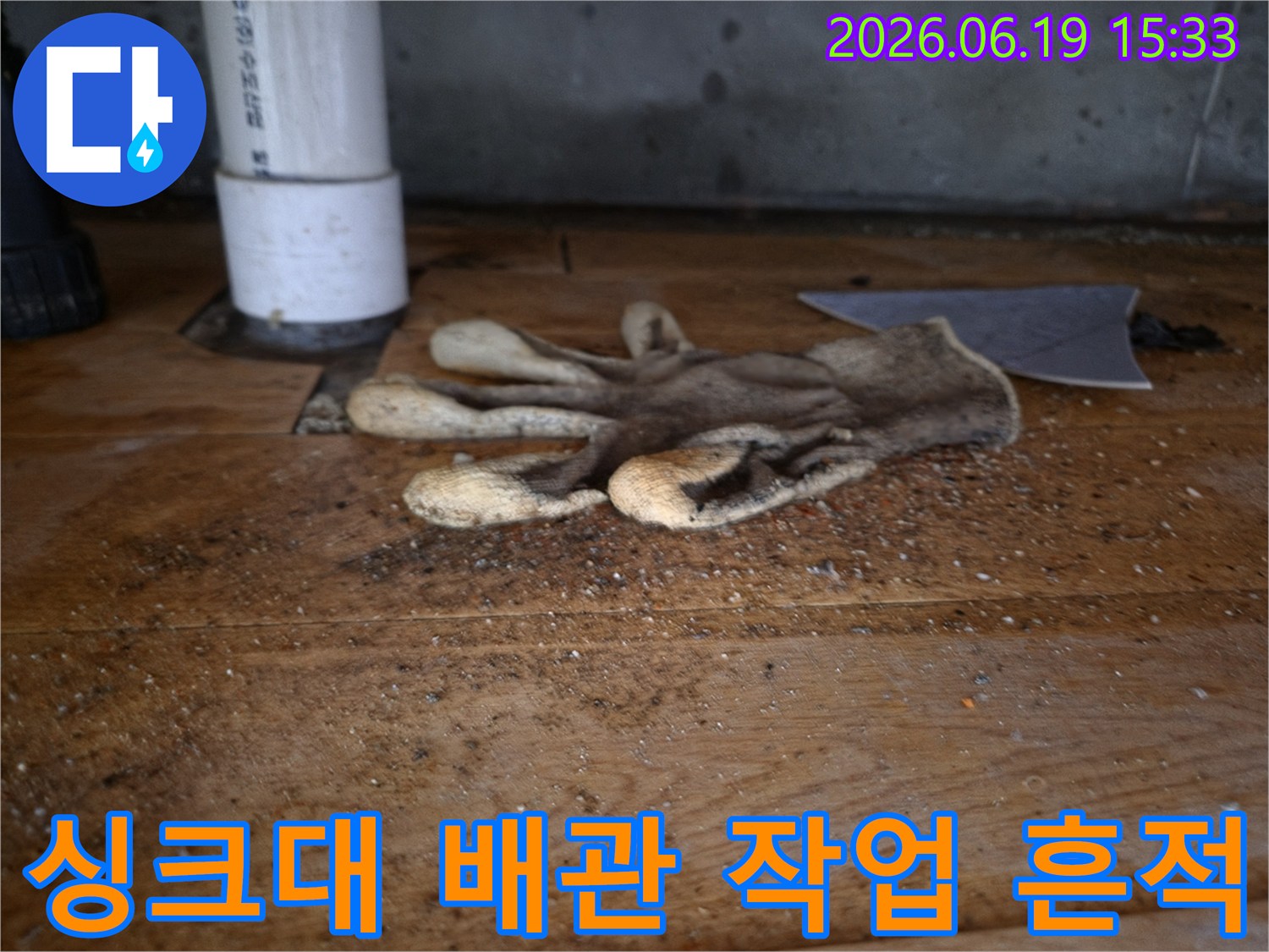 이 이미지는-싱크대 역류로-인한-배관 공사 현장의-작업용 장갑과-주변의-오염된-모습을-보여줍니다