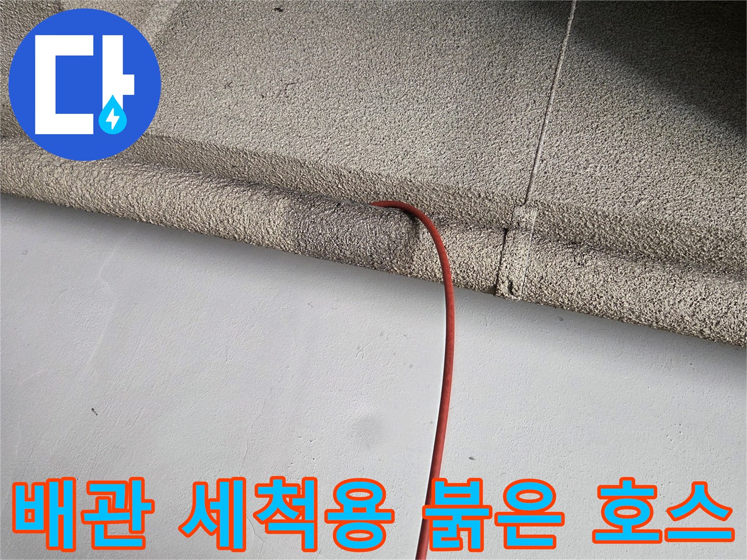 배관 입구 쪽으로 들어가는 고압 세척 호스의 근접 촬영입니다.
