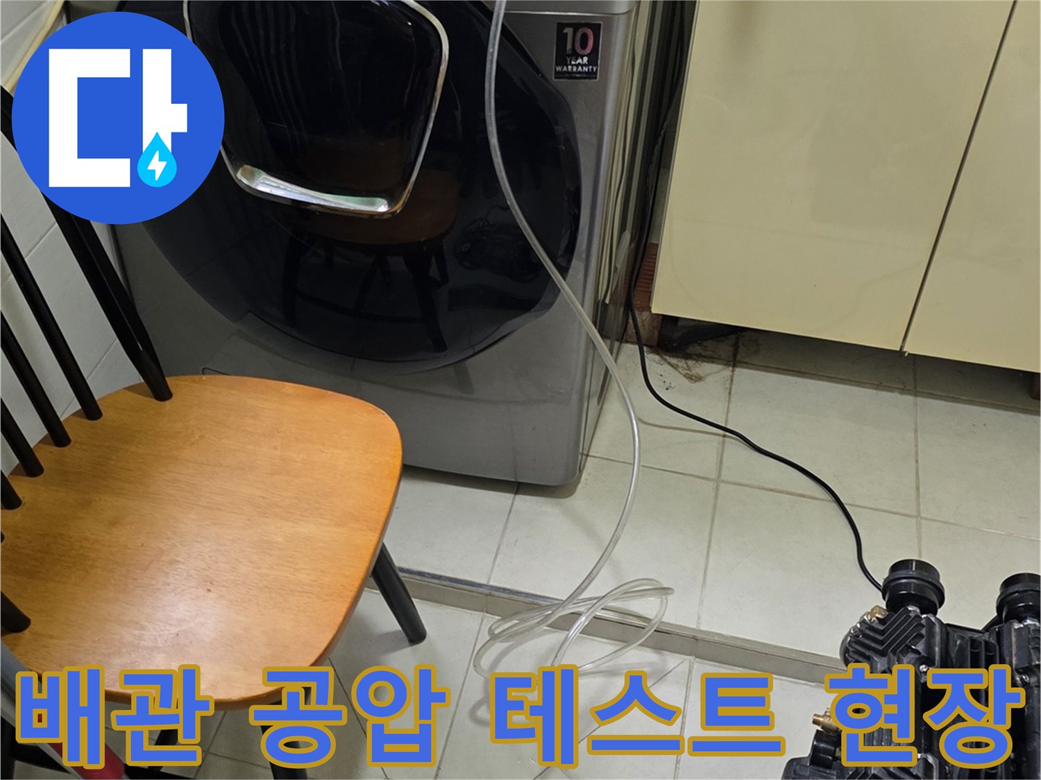 세탁기 옆 배관에 호스를 연결하여 압력을 주입하는 작업 모습