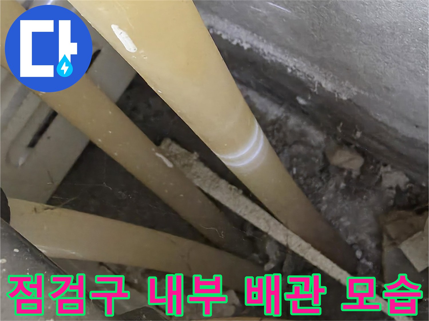 천장 점검구를 통해 들여다본 노란색 온수 배관과 주변 구조물