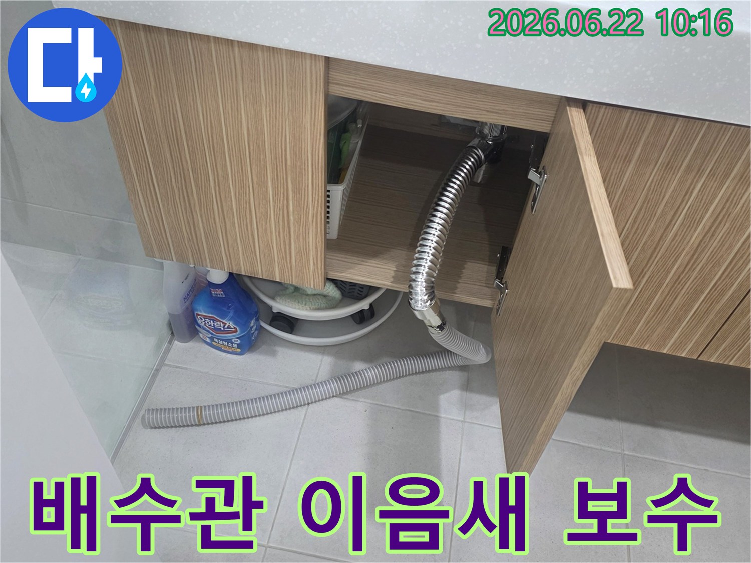 세면대 하부장 내부에서 배수관 이음새가 헐거워져 물이 새는-누수 현장을 정밀하게 보수하는 모습