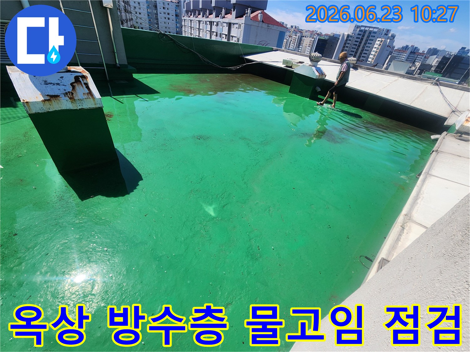 이 이미지는-송파구 거여동 옥상에서-방수층의 문제로 인한-물고임 현상을-전문가가 점검하는 모습입니다.