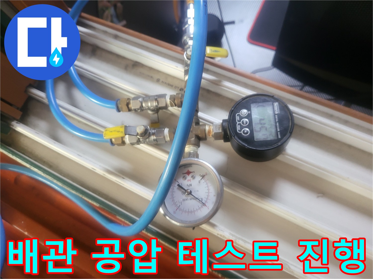 파란색 호스로 연결된 압력 측정 장치와 게이지의 근접 촬영