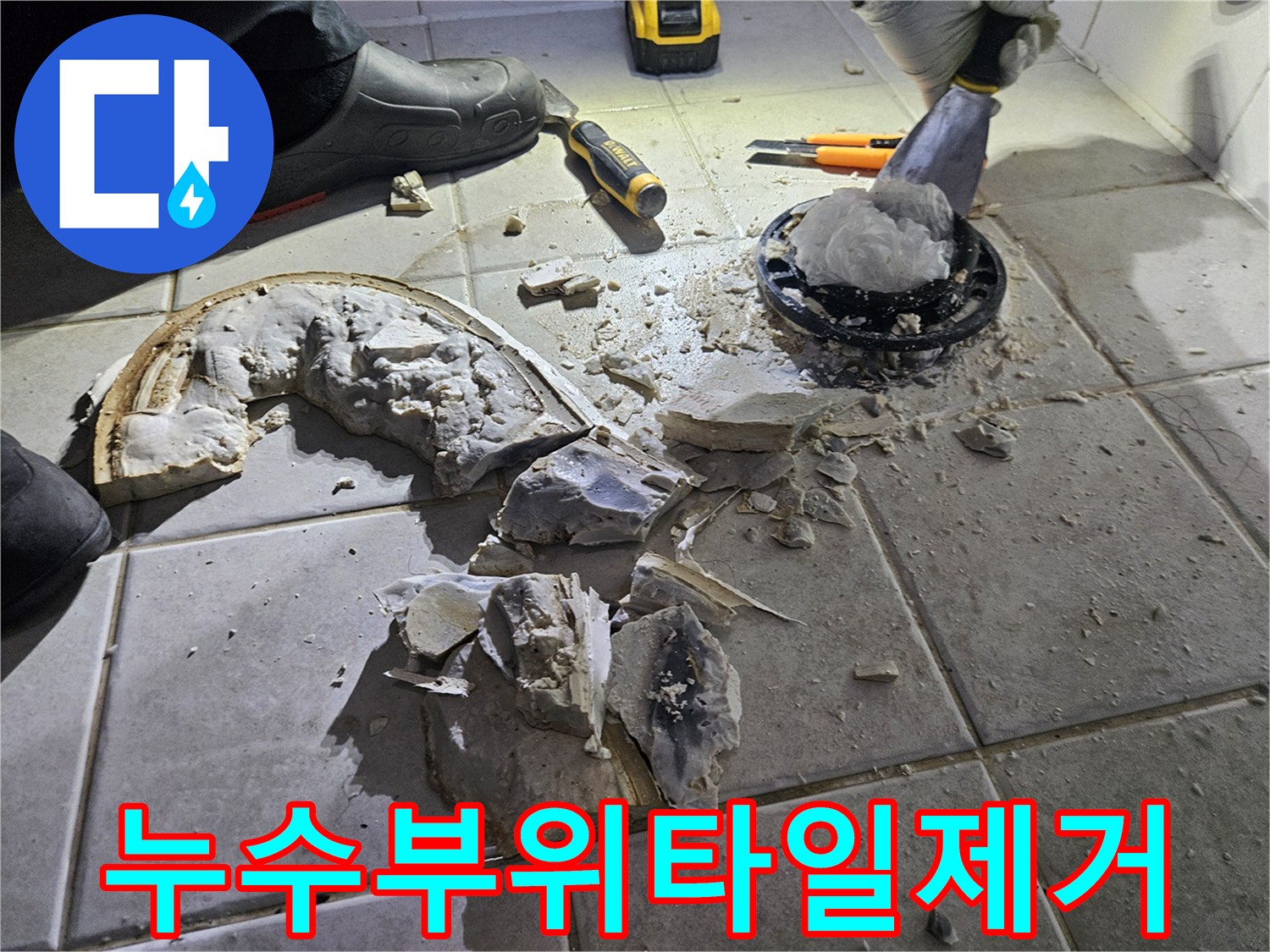 변기 탈거 후 드러난 오배수관 주변의 파손된 타일과 공구들입니다.
