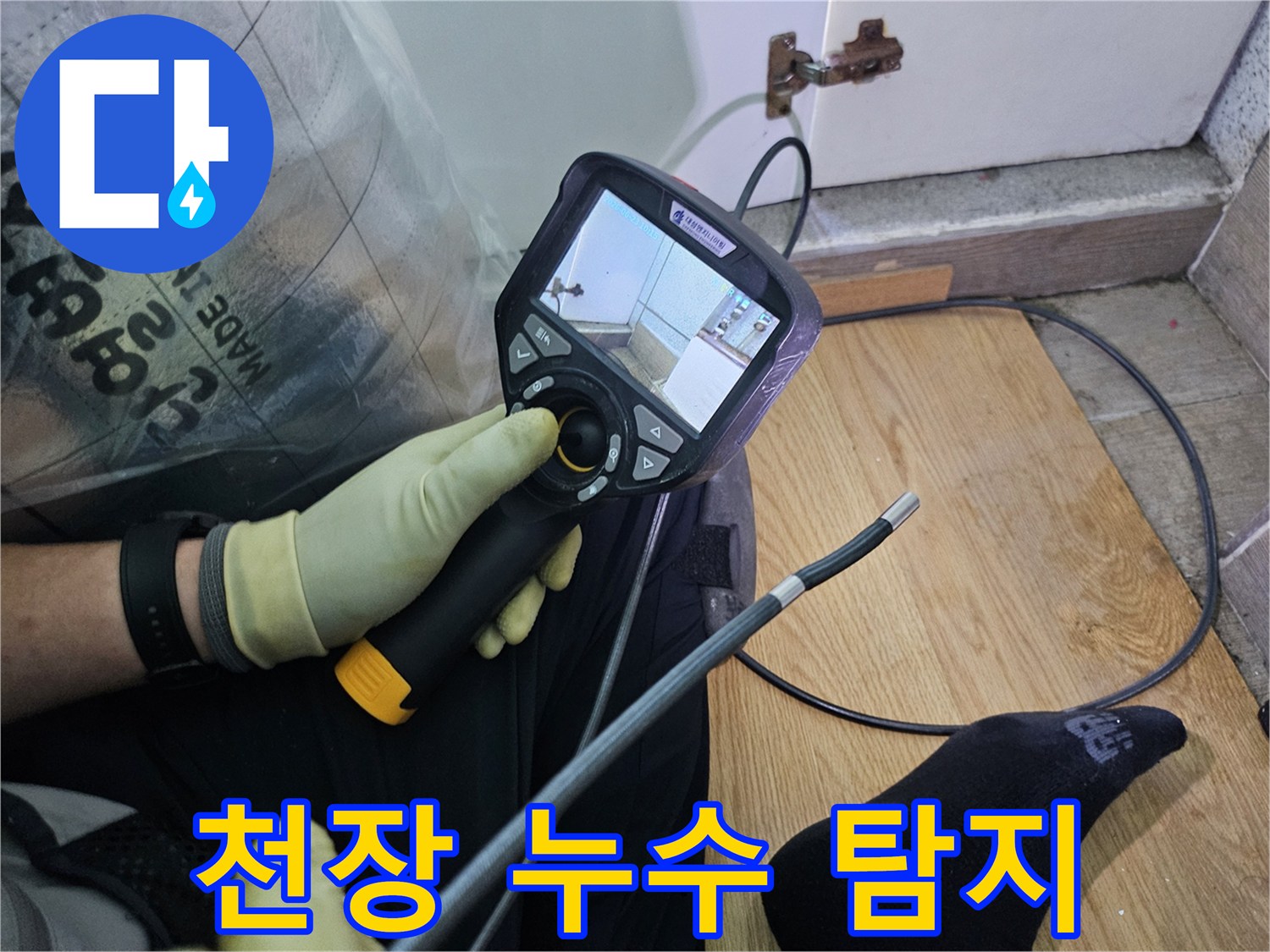 이 이미지는-숙련된 기술자가-누수 문제를 해결하고자-내시경 탐지기로-숨겨진 배관의 상태를 확인하는 과정입니다.
