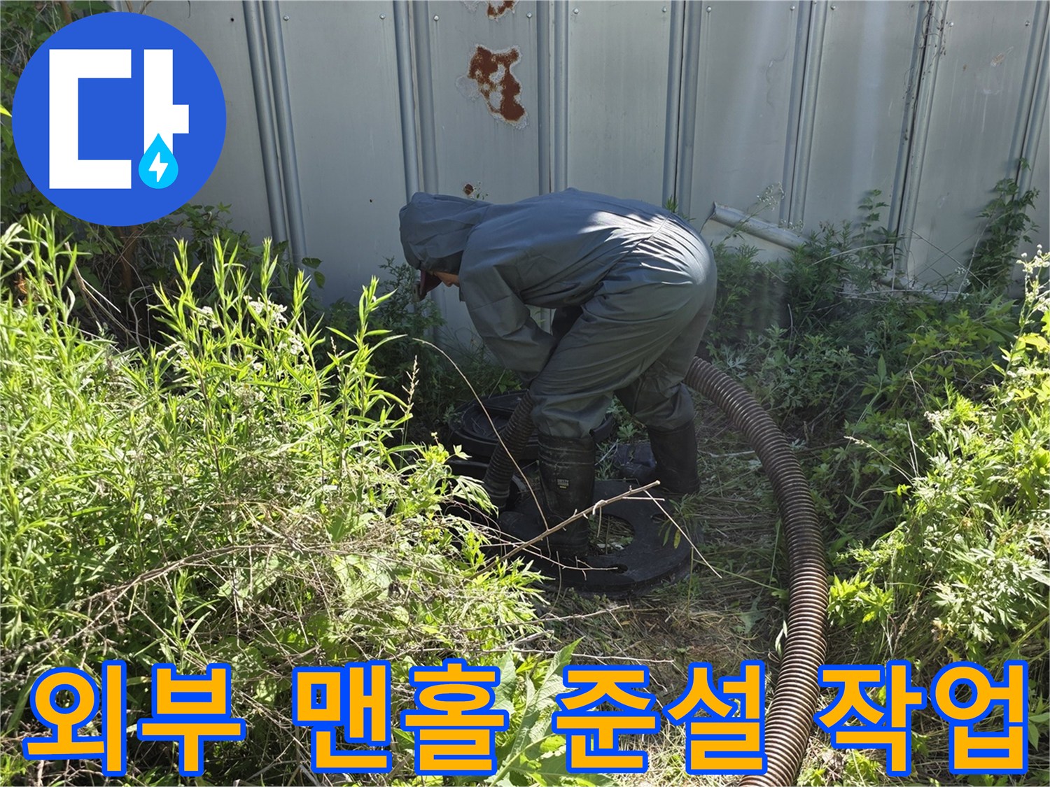 풀이 무성한 외부 맨홀 부근에서 진행되는 배관 청소 작업