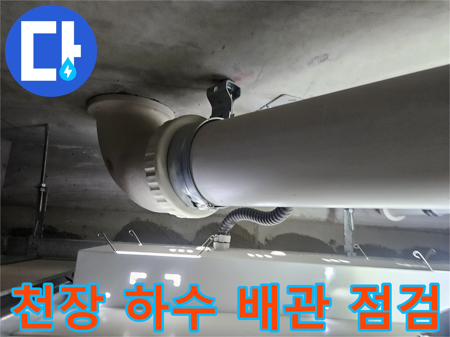 천장 구조물에 고정된 하수 배관의 연결 상태 사진