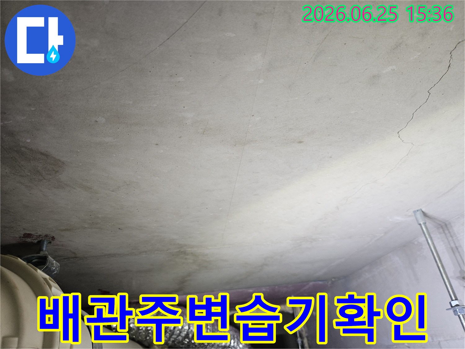 천장 콘크리트와 노출된 배관-덕트 주변에 나타난 젖은 흔적과-습기로 인한 변색을 촬영한 현장 사진입니다.
