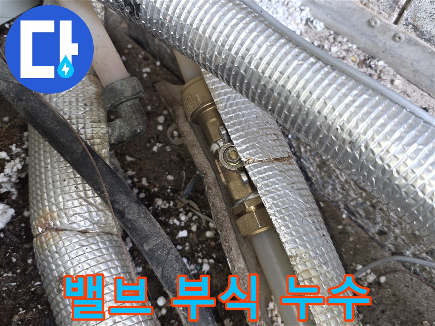 단열재-틈새로-드러난-부식된-배관-밸브에서-발생한-누수를-확인하는-전문가의-모습