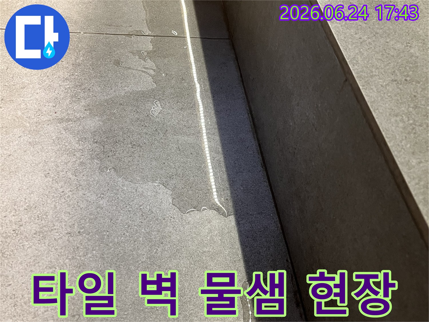 이 사진은 성남 위례 아파트의-욕실 타일 벽면에서-물이 새어 나오는-현장을 담고 있습니다-선반 아래쪽에서 시작된-물줄기가 벽을 따라-흐르고 있습니다