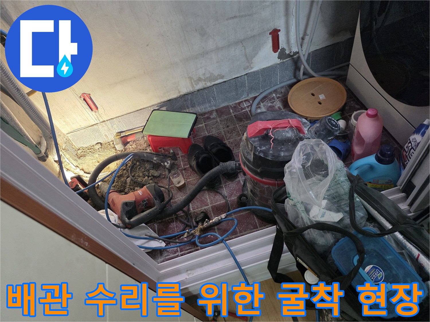 온수 배관 누수 지점을 확인하기 위해 타일을 제거하고 바닥을 굴착한 작업 현장 모습입니다.