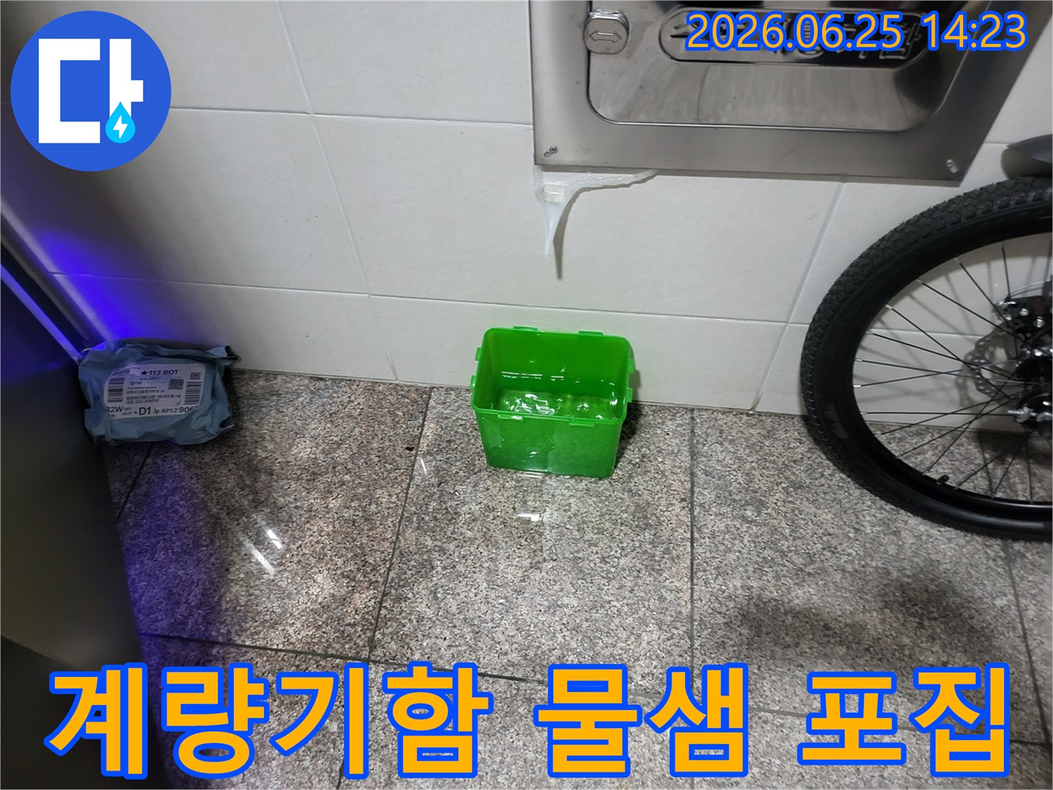 수도계량기함-아래에서-물이-새어-나와-초록색-물받이에-고이는-상황을-보여주는-누수-현장-사진