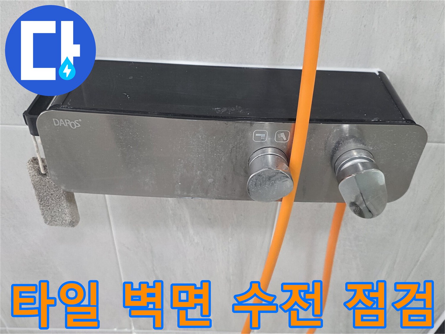 밝은색 타일 벽면에 설치된 금속제 수전 장치