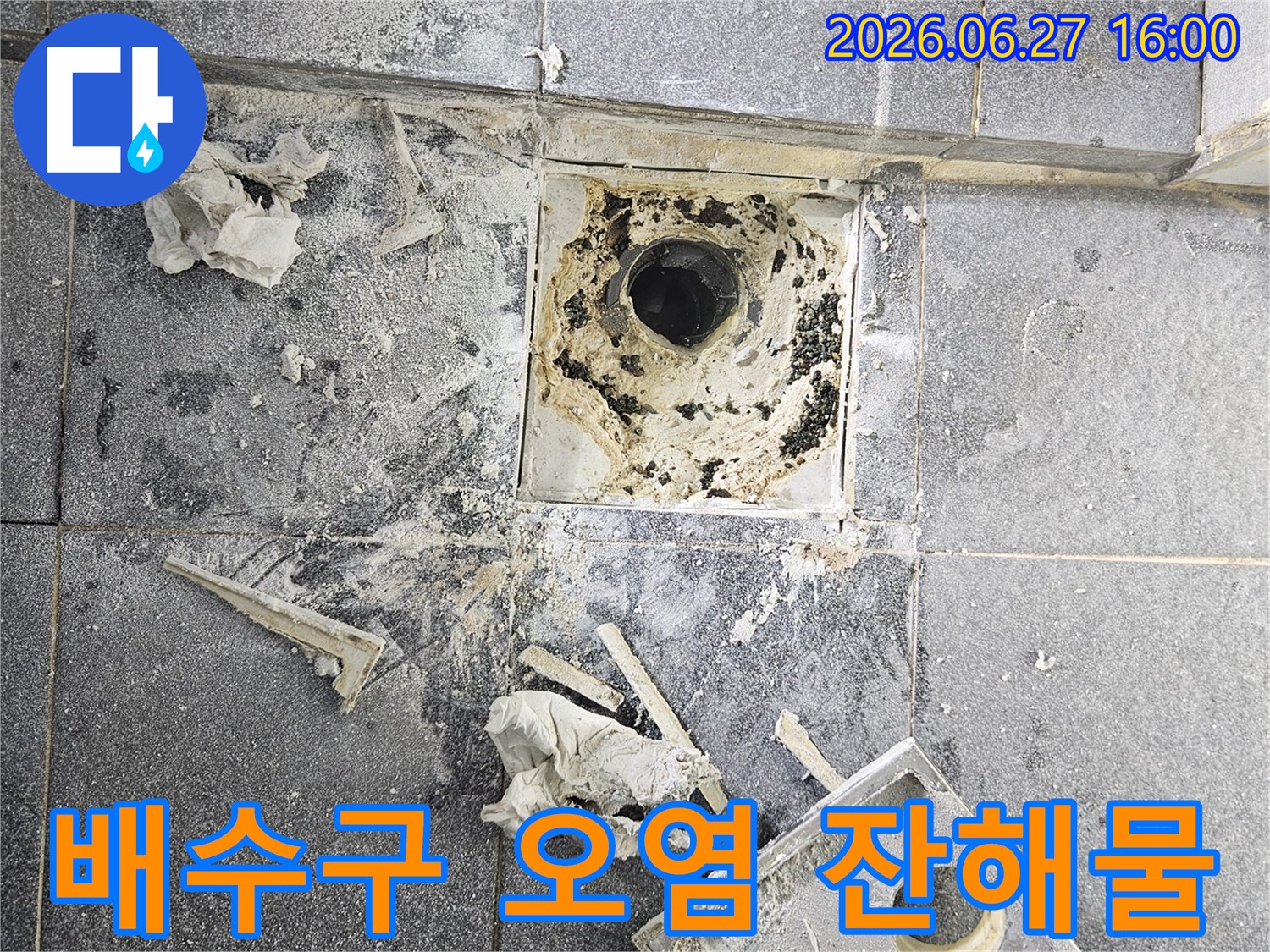 아파트 욕실 배수구 주변에-쌓인 오염물과-공사 잔해물을-보여주는 사진입니다