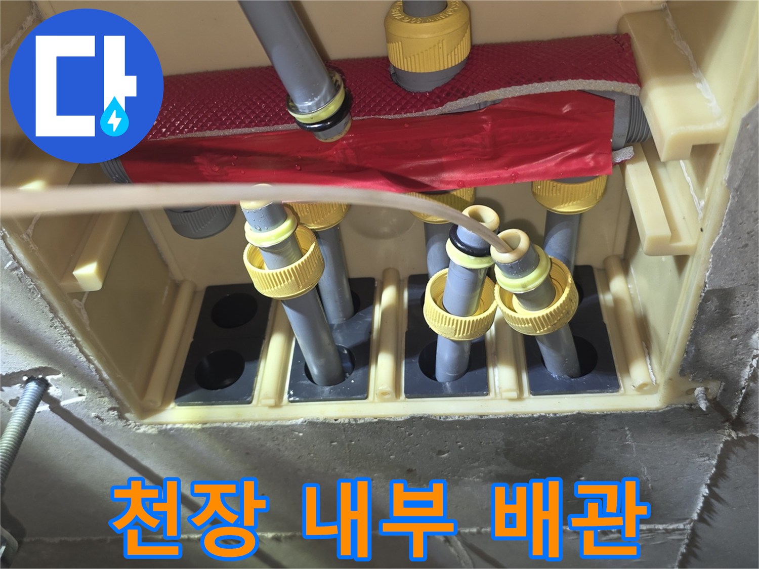 점검구 안쪽의 노란색 부속과 흰색 급수 배관 모습