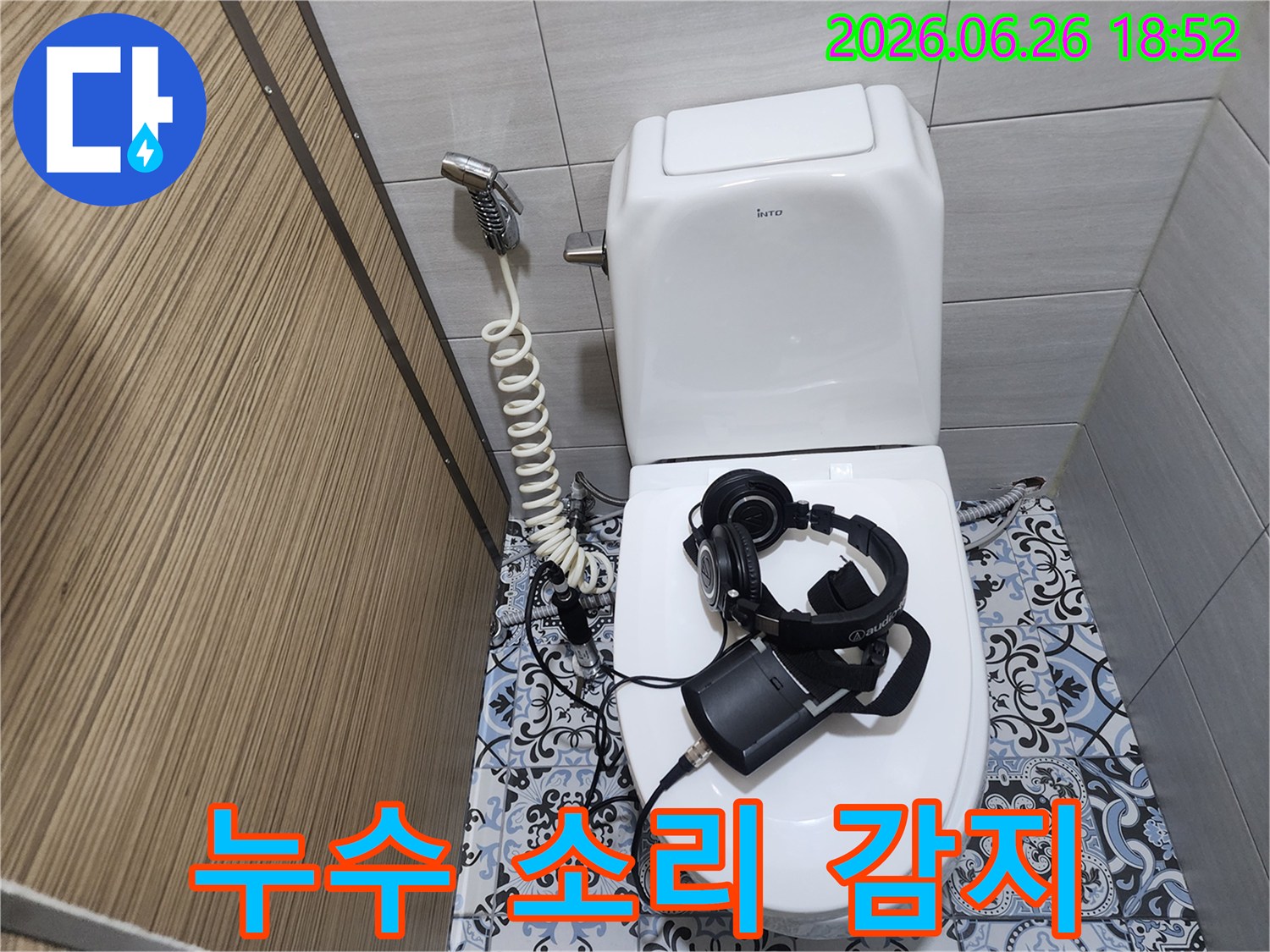 누수 탐지 장비와-헤드셋을-이용하여-화장실 변기에서-새는-미세한 물소리를-감지하는-전문가의-모습