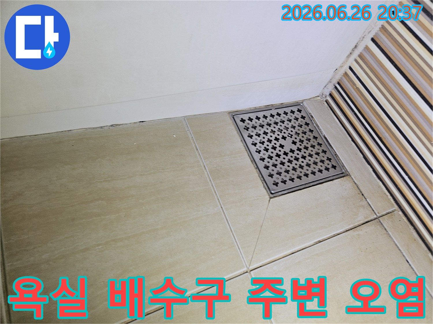 이 사진은-욕실 배수구와-인접한 타일-줄눈에서 나타난-물때와 오염을-자세히 보여줍니다