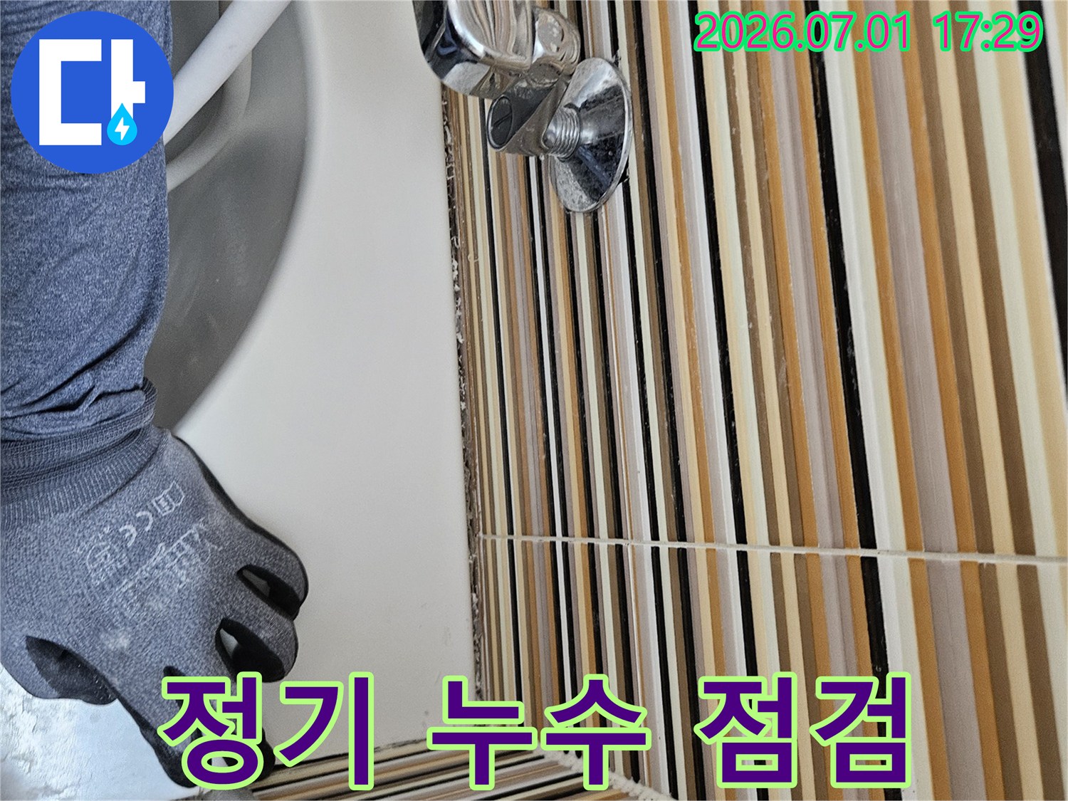 누수 전문 엔지니어가-세면대 하부 배관의-누수 여부를 정기적으로-점검하고 관리하는 모습