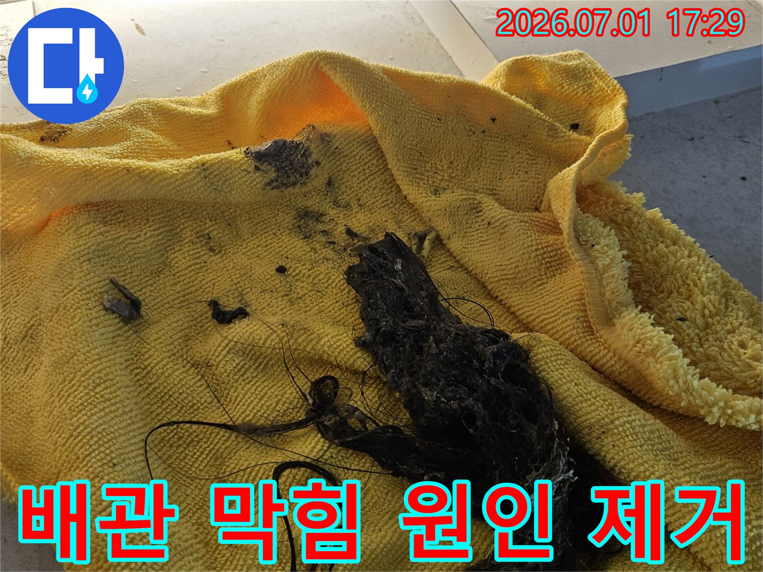 배수관에서 제거된-머리카락과 슬러지-오염물질이 담긴-노란색 수건의 모습입니다