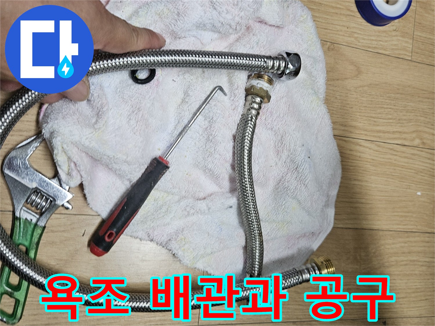새로 교체할 욕조용 은색 주름관과 몽키스패너 작업 도구들