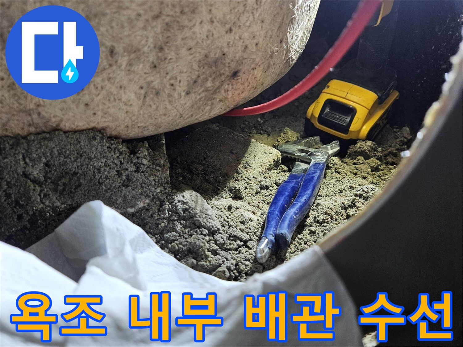 작업 도구가 배치된-욕조 하단 배관 점검 부위