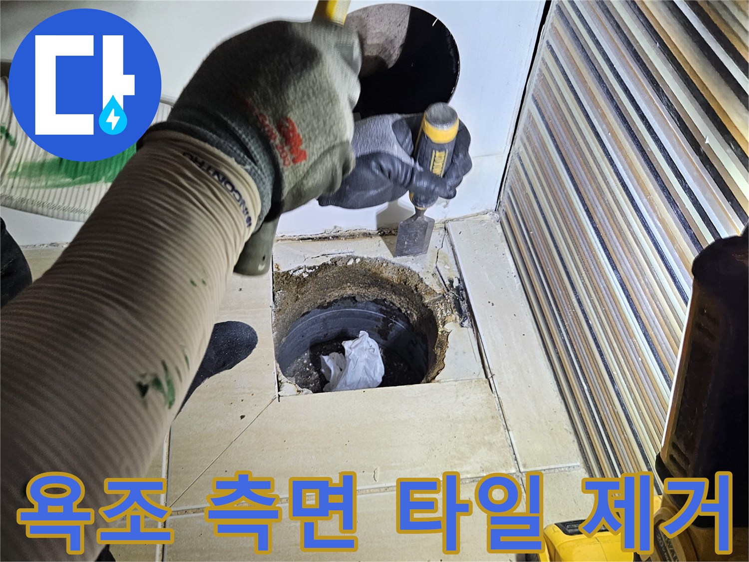 작업자가 타일을 제거하여 배관을 노출시킨 모습