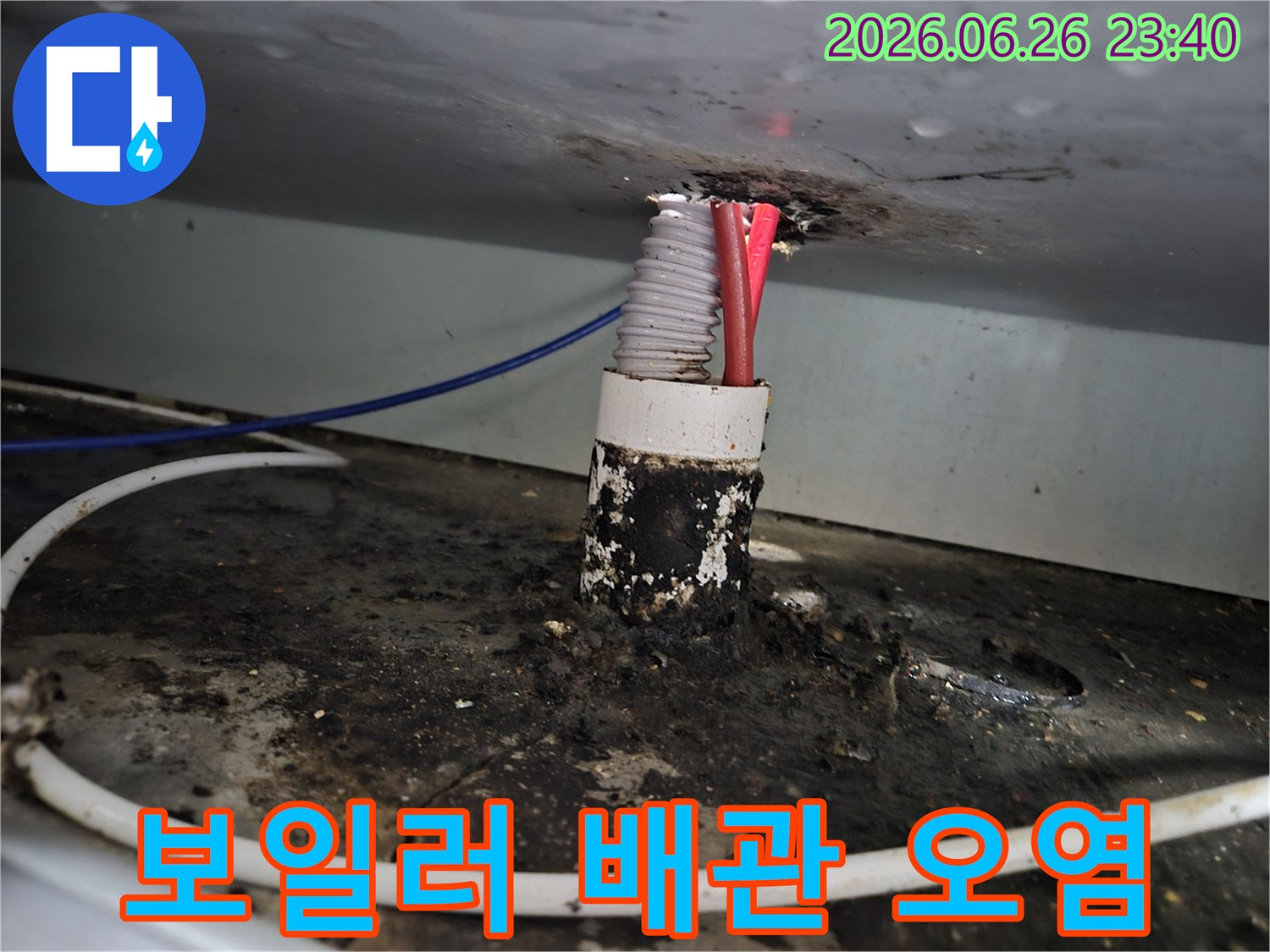 주택 보일러실 배관 연결부에서 발생한 누수로 인해-주변이 심하게 오염된 상태를 보여주는 사진입니다.