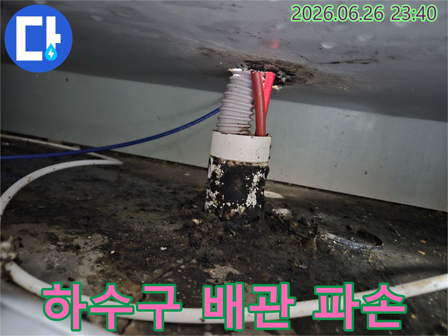 주택 하수구 배관 틈새에서 발생한 누수로 인해-주변이 심하게 오염되고 배관이 파손된 상태를 보여줍니다.