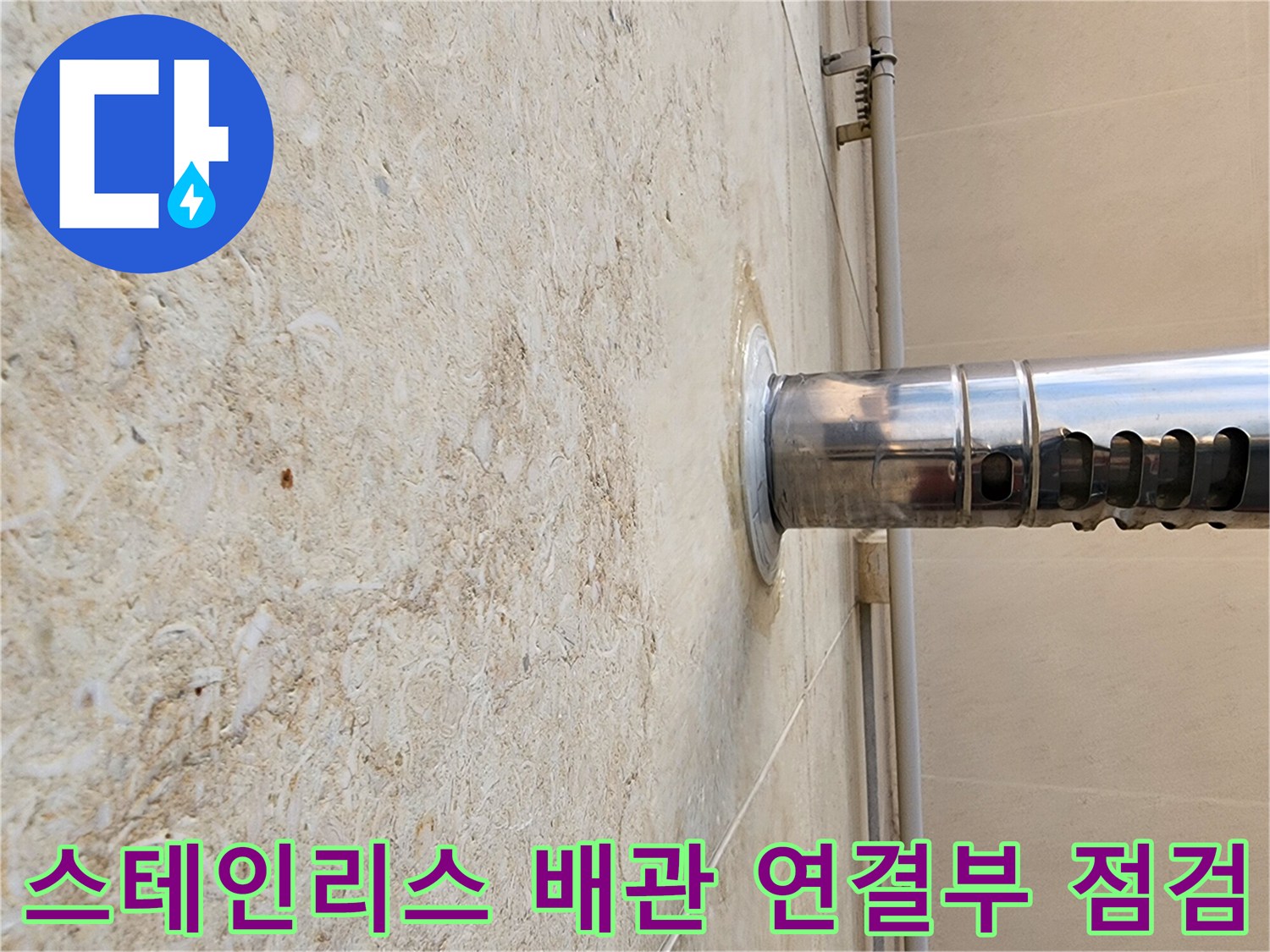 외벽 석재 사이로 돌출된 스테인로스 배수관의 마감 상태를 촬영한 모습