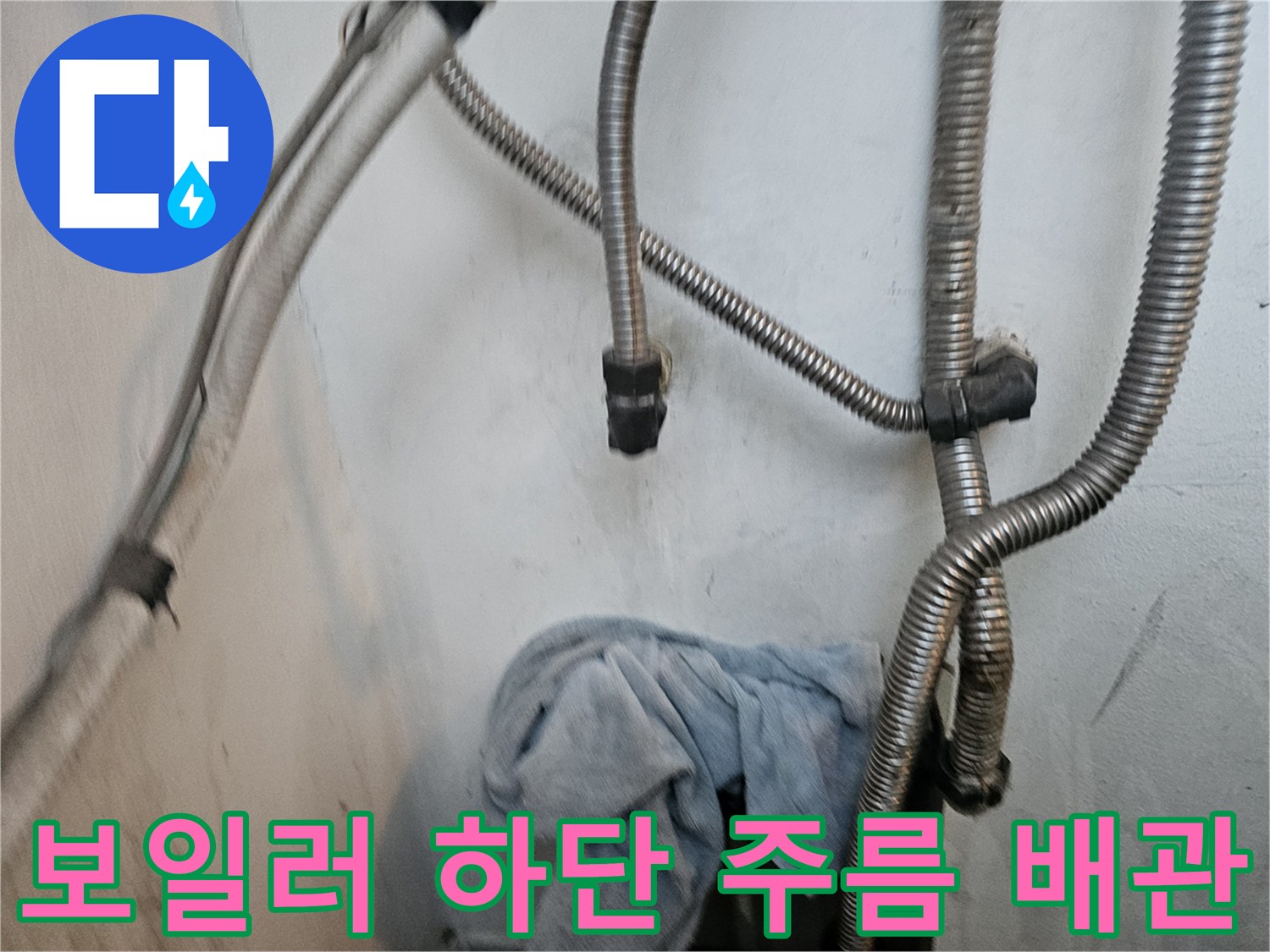 보일러 아래쪽 유연한 금속 배관과 벽면 연결부의 상태 사진