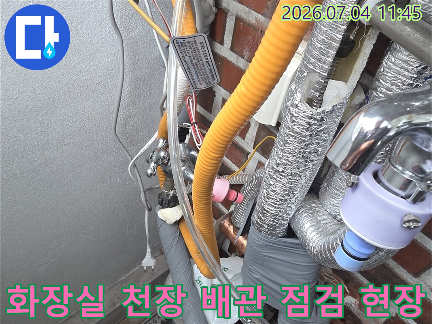 천장 내부 노출된 배관과 단열재를 점검하는 누수 전문가의 작업 모습