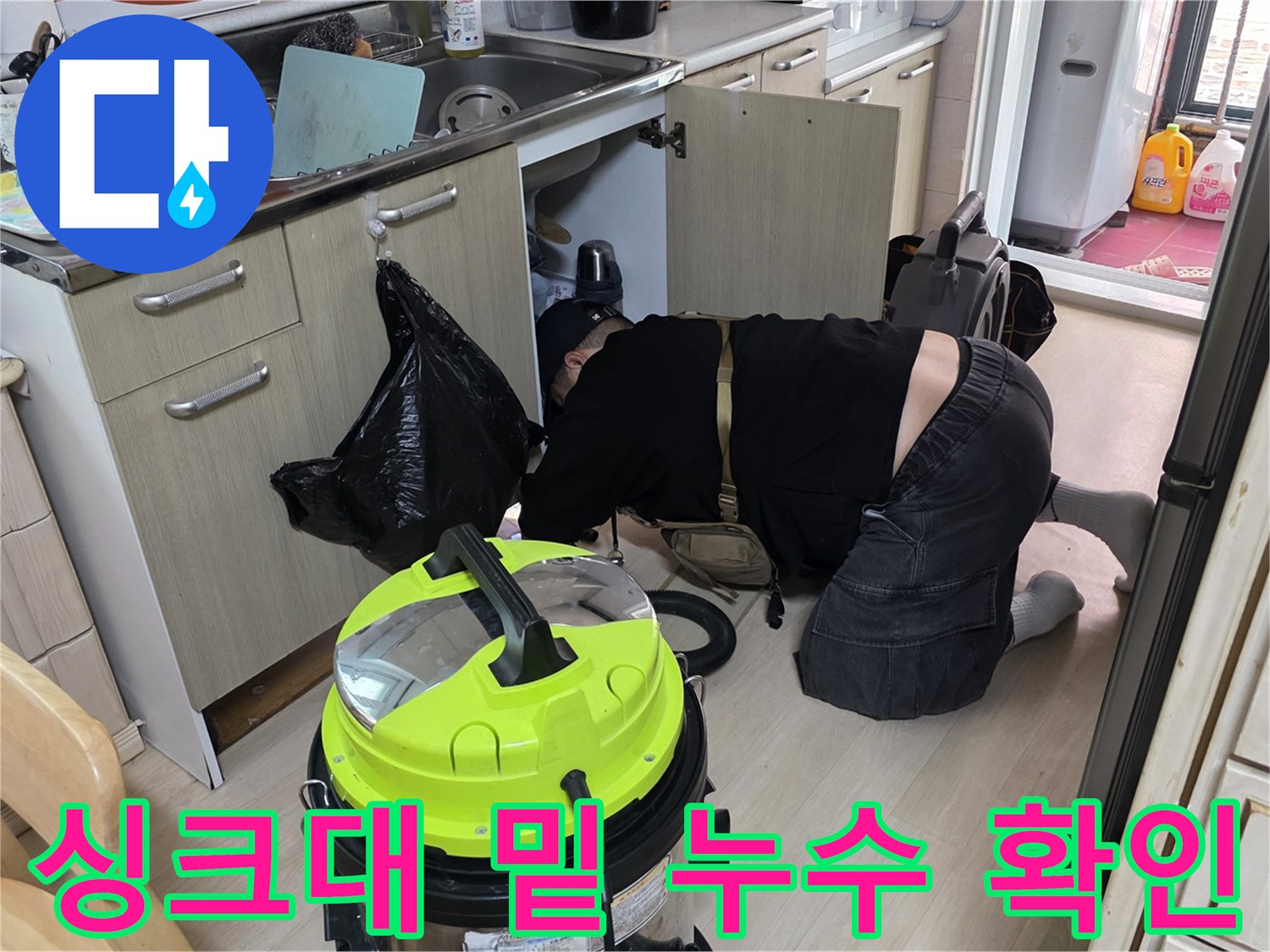 싱크대 하부장 아래쪽의 물 고임 현상을 정밀하게 진단하는 모습