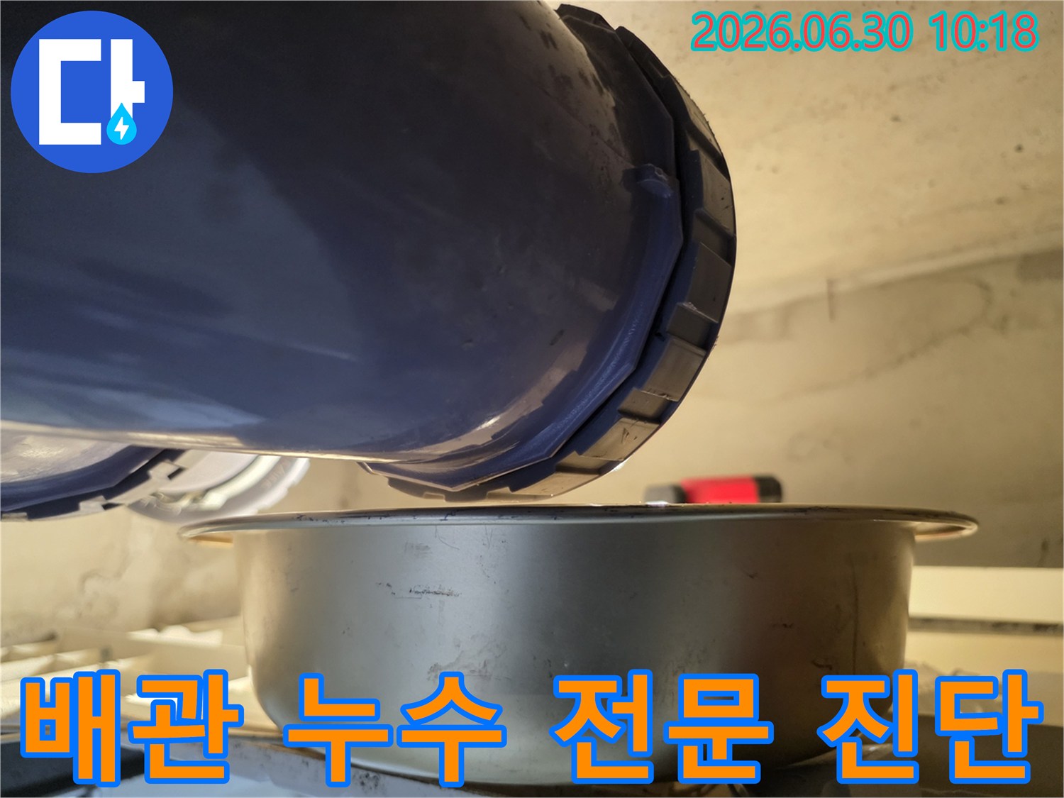 누수-현장에서-배관의-연결-부위에서-물이-새는-것을-발견하고-아래에-물받이를-놓아-누수-상황을-전문적으로-진단하고-있는-모습입니다.