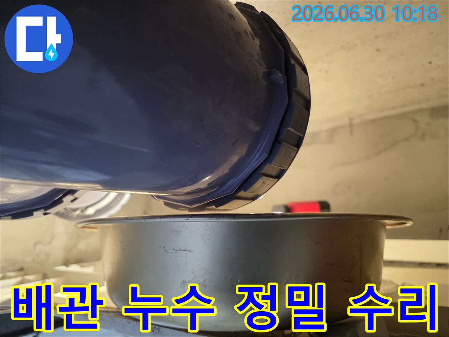 누수-현장에서-배관의-이음새-부분에서-물이-새는-것을-발견하고-아래에-물받이를-놓아-정밀하게-탐지하고-수리-계획을-세우는-사진입니다.
