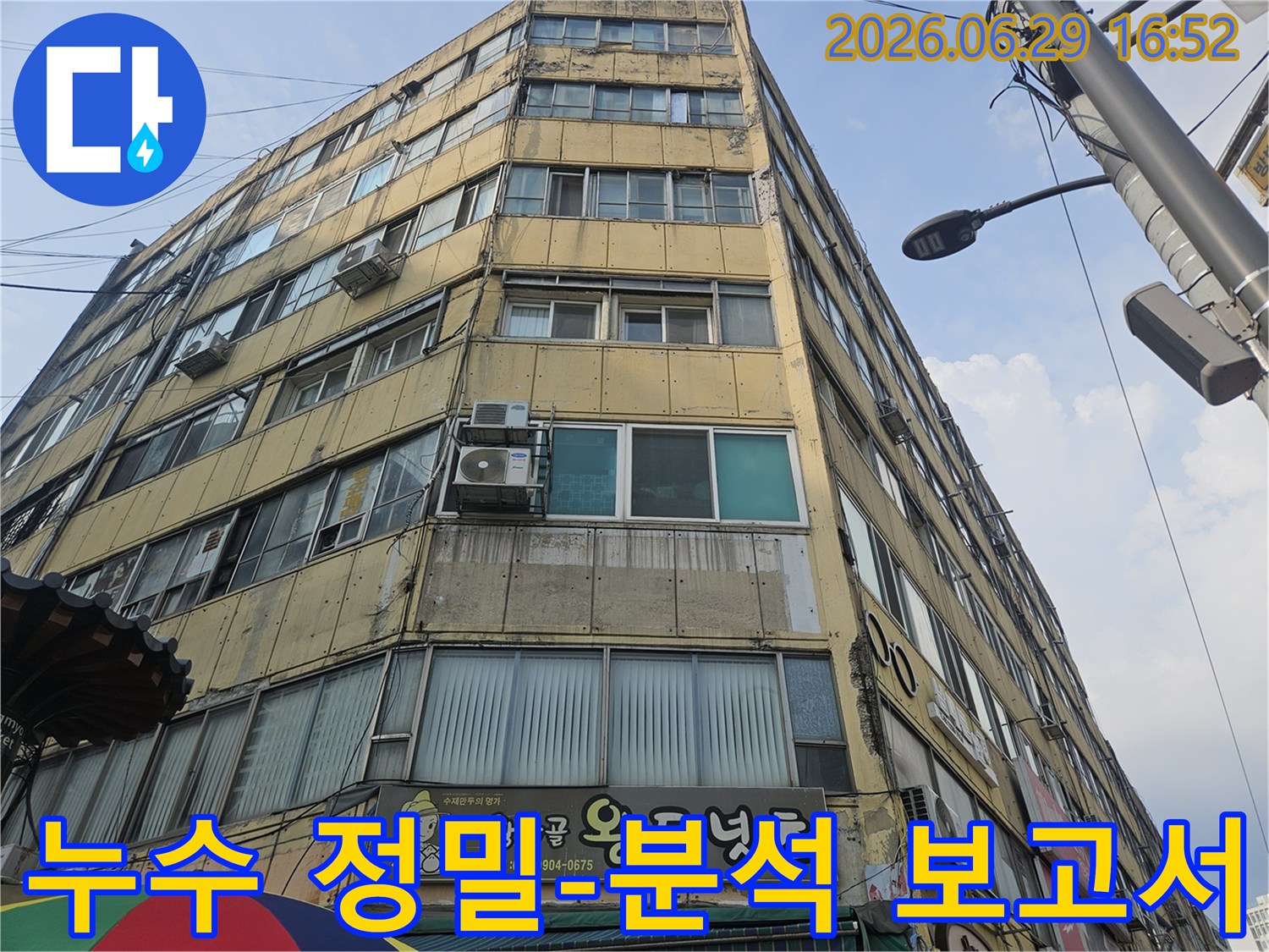 오래된 상가 건물의-외벽 누수 원인을-정밀 분석하고-보고서를-작성하기 위해-현장을-점검하는-전문가의-모습