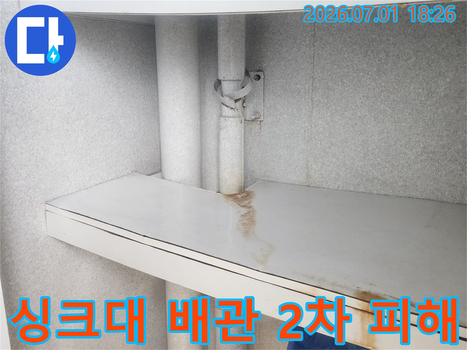 이 이미지는-싱크대 하부-배관 누수로 인해-가구 패널에-발생한-물 자국과-부식 흔적을-보여주며-2차 피해의-위험성을-경고합니다