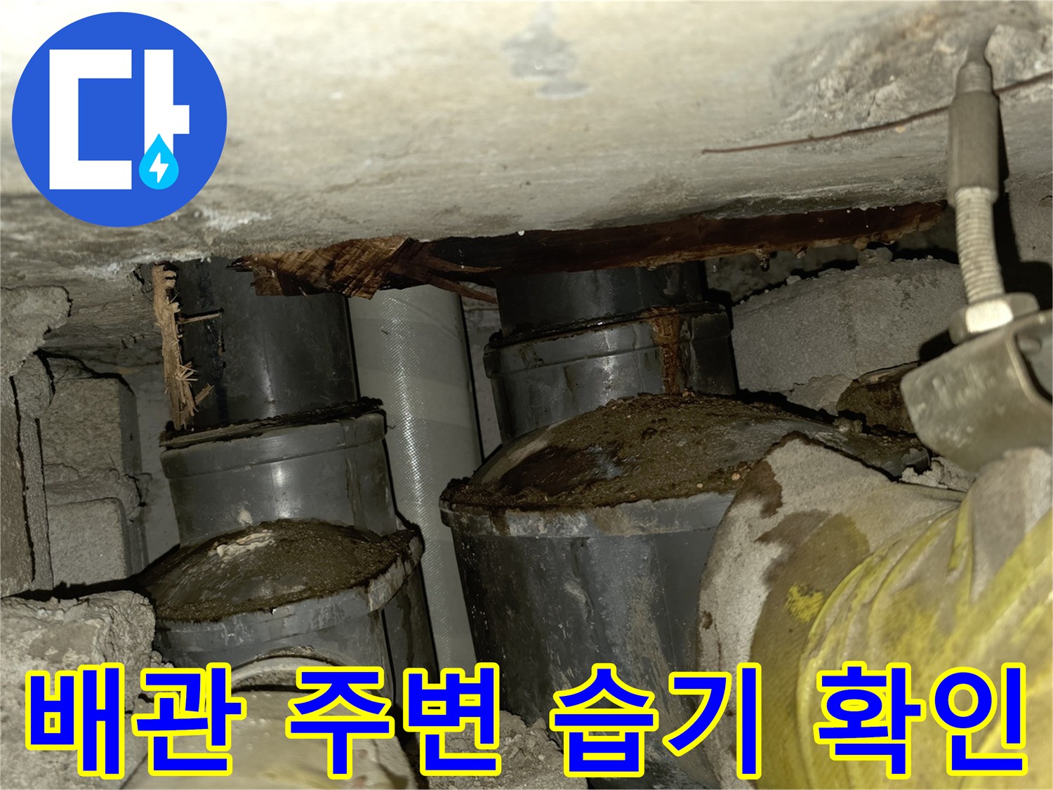 콘크리트 천장 배관 주변의 습기와 누수 흔적을 살펴보는 사진